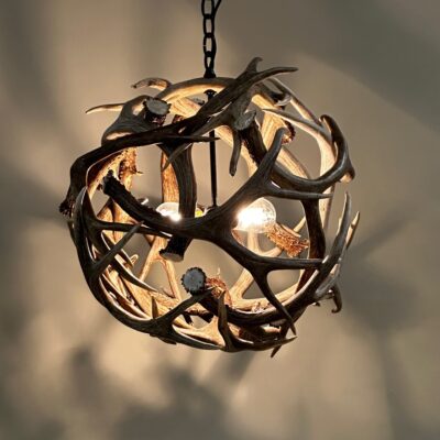 Unique Antler designs a Antler Globe chandeliers. This is made out of mule deer horns. We individually select every antler. These antlers are inspected and graded on look, shape, quality, age, and weight. Our chandeliers are out of the best looking sheds. Every chandelier is a work of art, we put in the time and precision to make sure our customers are happy. Our chandeliers are fully tested, and come with everything you will need to install into a ceiling box along with a chain. Our Antler Globe chains is black matching our light inside the globe.  Other colors are available upon request. Our chandeliers are handcrafted using many types of antler to create a grand yet simple piece of functional art, fit for your home. 